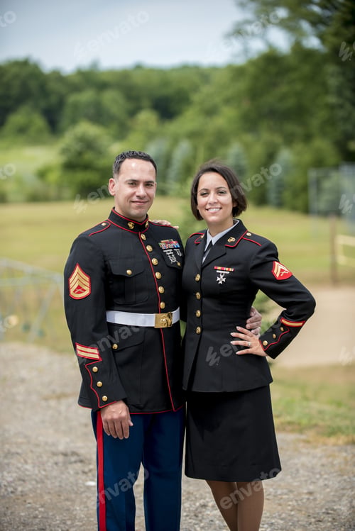 Preview: Vertical shot of a military couple hugging while smiling at the camera