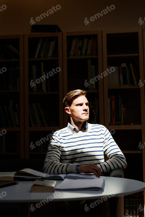 Preview: Thoughtful student sitting at desk in classroom