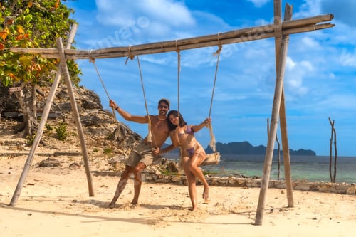 Preview: Tourists swinging on a bamboo swing on bulog dos island, coron, philippines