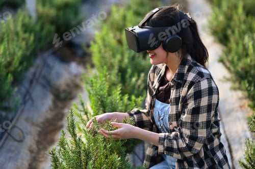 Preview: Smiling female farmer in VR glasses for digital management of greenhouse cultivation.
