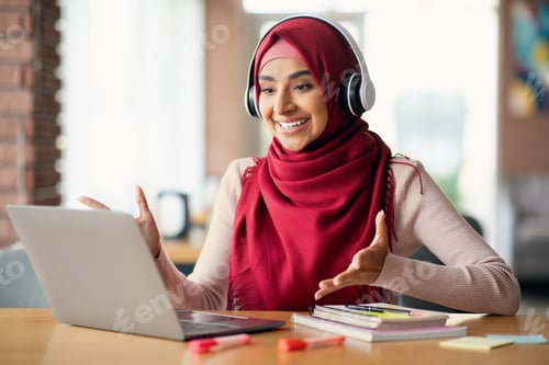 Preview: Happy muslim woman having video conference with colleagues