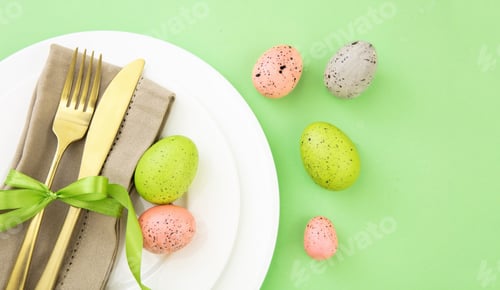 Preview: Easter table setting, Easter eggs decoration, napkin and golden cutlery on white plates