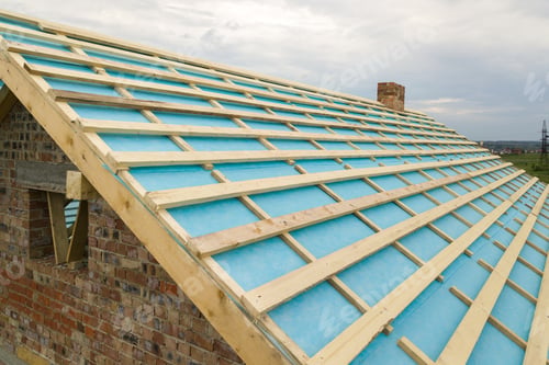 Preview: Aerial view of a brick house with wooden roof frame under construction