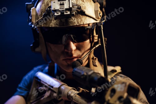 Preview: US special forces soldier looking at the aim ready to shoot against black dark background