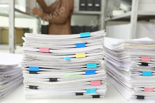 Preview: Stacks of documents with paper clips on office desk