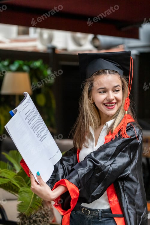 Preview: Vertical photo of young lady wears graduation cape and holding notebook