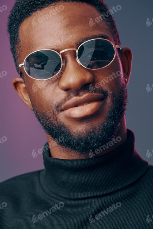 Preview: Stylish young man wearing sunglasses, showcasing confident expression against colorful background