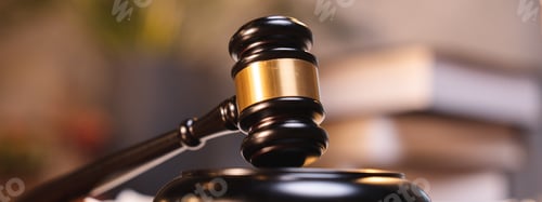 Preview: Judge gavel on the table with blurry books in the background