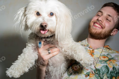 Preview: Man having a joyful moment with his fluffy white dog
