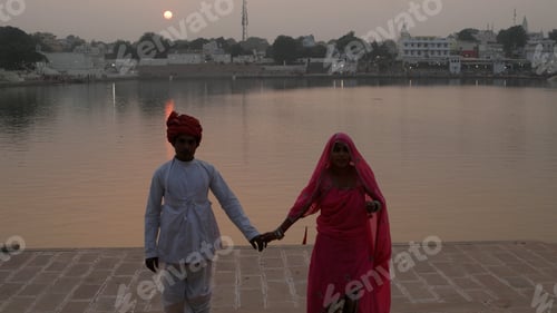 Preview: Indian couple in traditional outfits with River Ganges in the background.