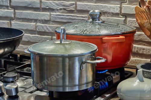 Preview: Pots with cooking food in the kitchen on gas stove.