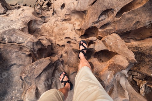 Preview: Man legs with hiking shoes standing on rugged rock of grand canyon in Thailand