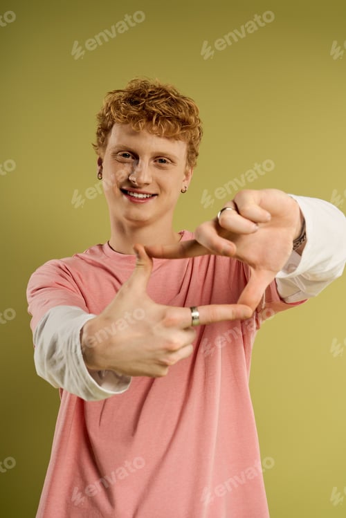 Preview: Young man making a playful gesture against a trendy green backdrop