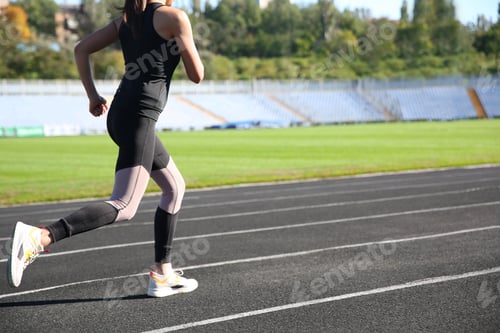 Preview: Sporty woman running at stadium on sunny morning