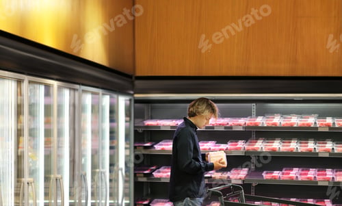 Preview: Man Choosing Frozen Food From A Supermarket Freezer