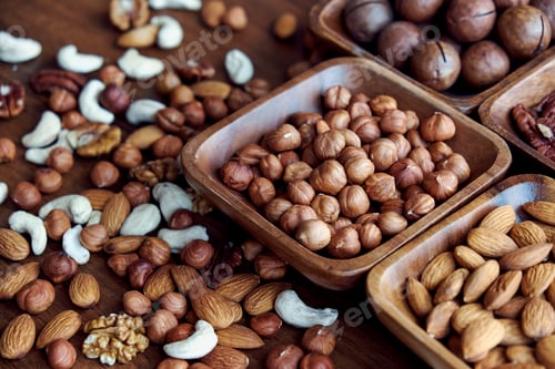 Preview: Wooden bowl with mixed nuts on table top view. Healthy food and snack