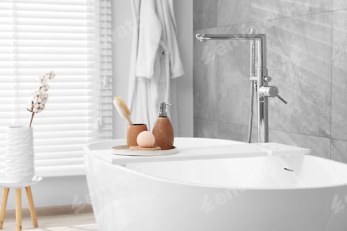 Preview: Different personal care products and accessories on bath tub in bathroom