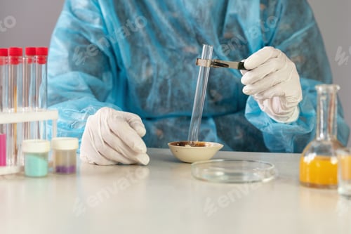 Preview: Laboratory assistant sits in the laboratory and conducts chemical experiments