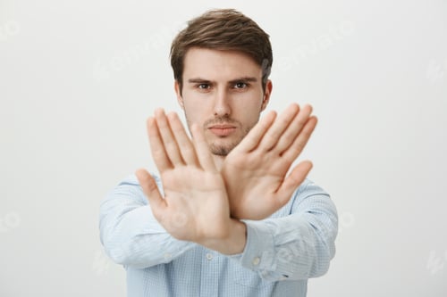 Preview: You cannot break rules. Portrait of strict confident handsome european guy pulling crossed palms