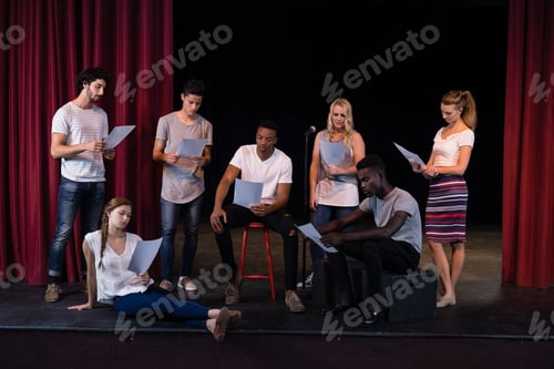 Preview: Actors reading their scripts on stage