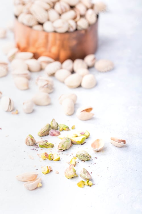 Preview: Pistachios spilling from a copper container