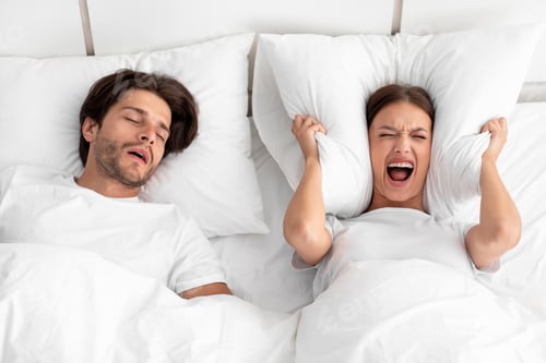 Preview: Unhappy european millennial woman awake lying in bed, shouting, covering ears with pillow