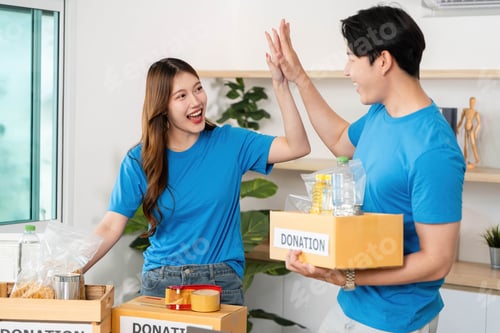 Preview: Donation Celebration. Volunteers high-fiving after successfully organizing donation boxes.