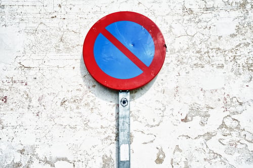 Preview: Round red blue no parking street sign on a white wall background
