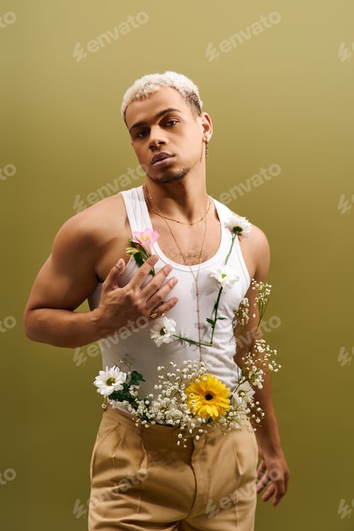 Preview: Handsome young African American man in trendy tank top adorned with flowers in studio