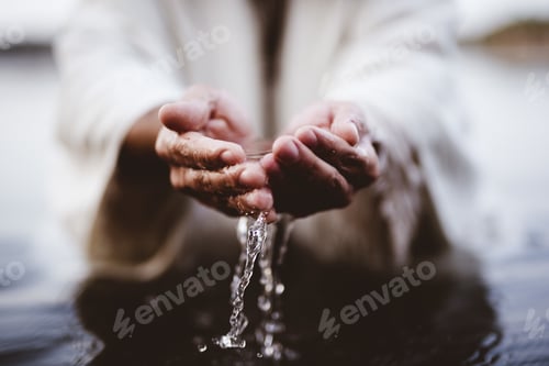 Preview: Closeup shot of a person drinking water with his hands with a blurred background