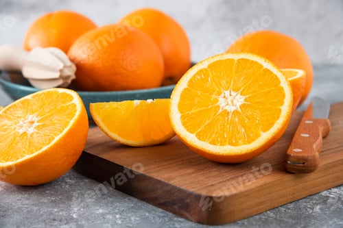 Preview: Sliced orange fruits with whole oranges on a wooden board