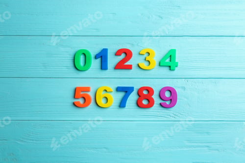 Preview: Colorful magnetic numbers on light blue wooden background, flat lay