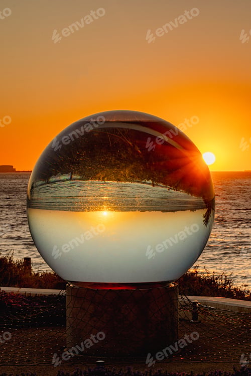 Preview: a glass ball of liquid that is sitting on a concrete pole
