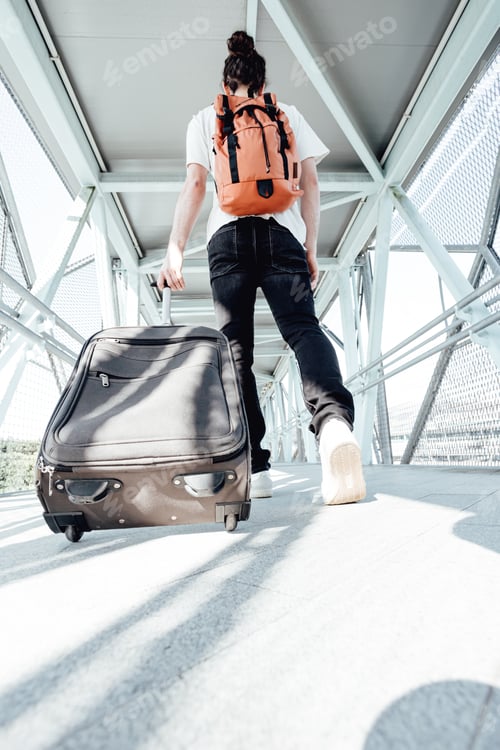 Preview: Back shot of a traveler carrying his luggage and bags at the airport or bus station during a travel