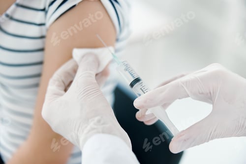 Preview: male doctor injections into patient's arm close-up covid vaccination