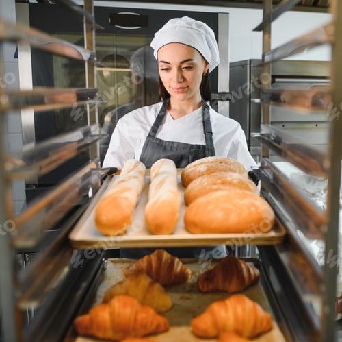 Preview: Baker putting tray of freshly baked bread and croissants into rack