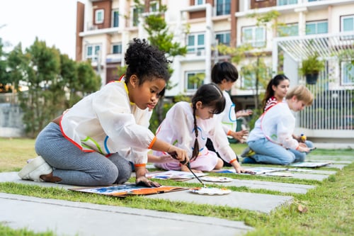 Preview: Group of student coloring on painting board outdoors in school garden. A