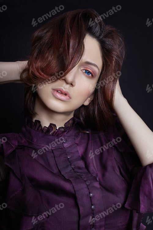 Preview: Contrast fashion Armenian woman portrait with big blue eyes on a dark background in a purple dress