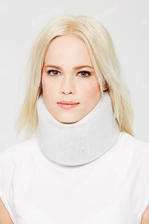 Preview: On the road to recovery. A beautiful young woman in a neck brace against a white background.