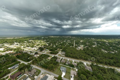 Preview: Dark stormy clouds forming on gloomy sky before heavy rainfall over suburban town area