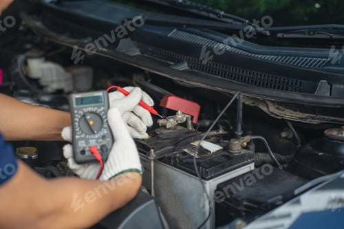 Preview: Close-up of mechanic holding voltmeter to check voltage car battery energy problem for service