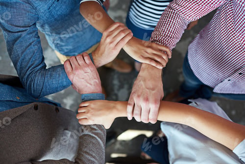Preview: Top view of co-workers hand put together in an expression of unity and team spirit