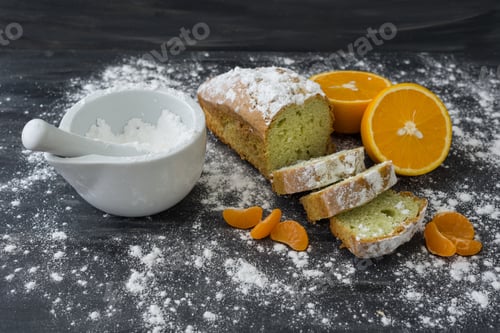 Preview: Mint cake sprinkled with powdered sugar on dark surface with fresh oranges mandarins