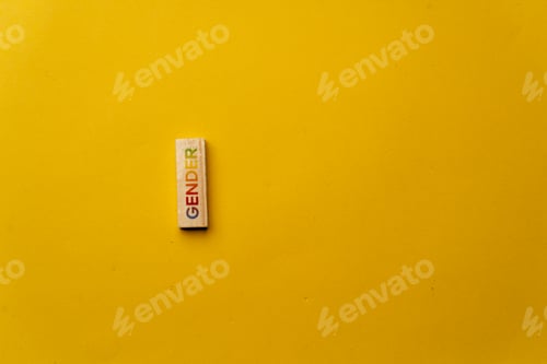 Preview: a yellow warm background without shadows wooden cubes with colored letters laid out word gender