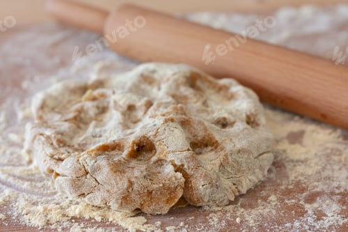 Preview: A raw piece of dough for gluten free chikpea flour chip cookies lies on table sprinkled with flour.