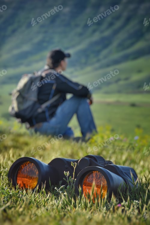 Preview: Man with a backpack sitting on the green grass
