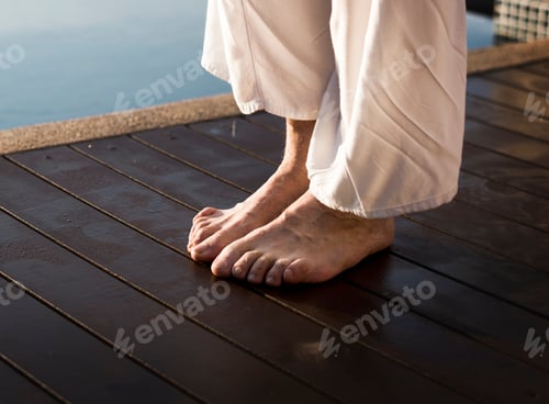 Preview: Senior adult practicing yoga by the pool