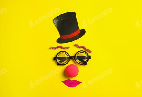 Preview: Funny face made with clown's accessories on yellow background, flat lay