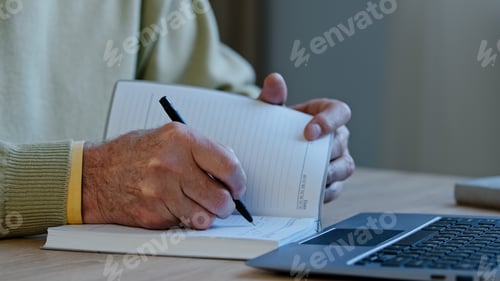 Preview: Unrecognizable mature man sit at workplace professor preparing lecture for students remote