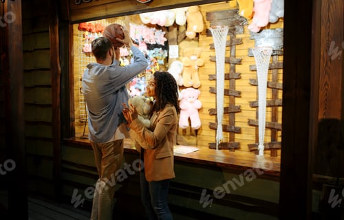Preview: Couple play in shooting gallery, amusement park